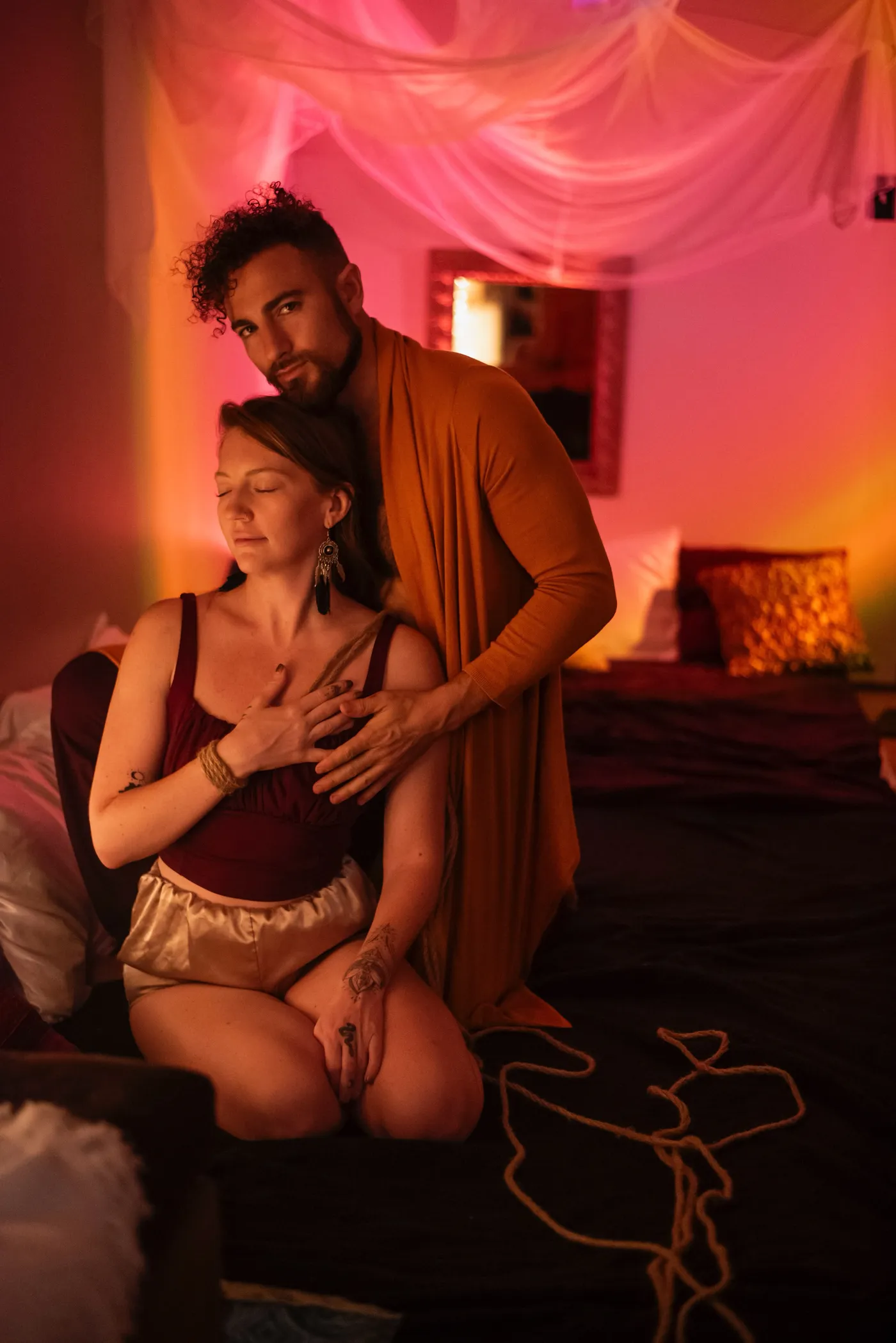 Ross and Eden of Sacred Society under a pink silk canopy